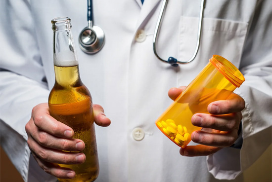 Врач с алкоголем и таблетками в руках